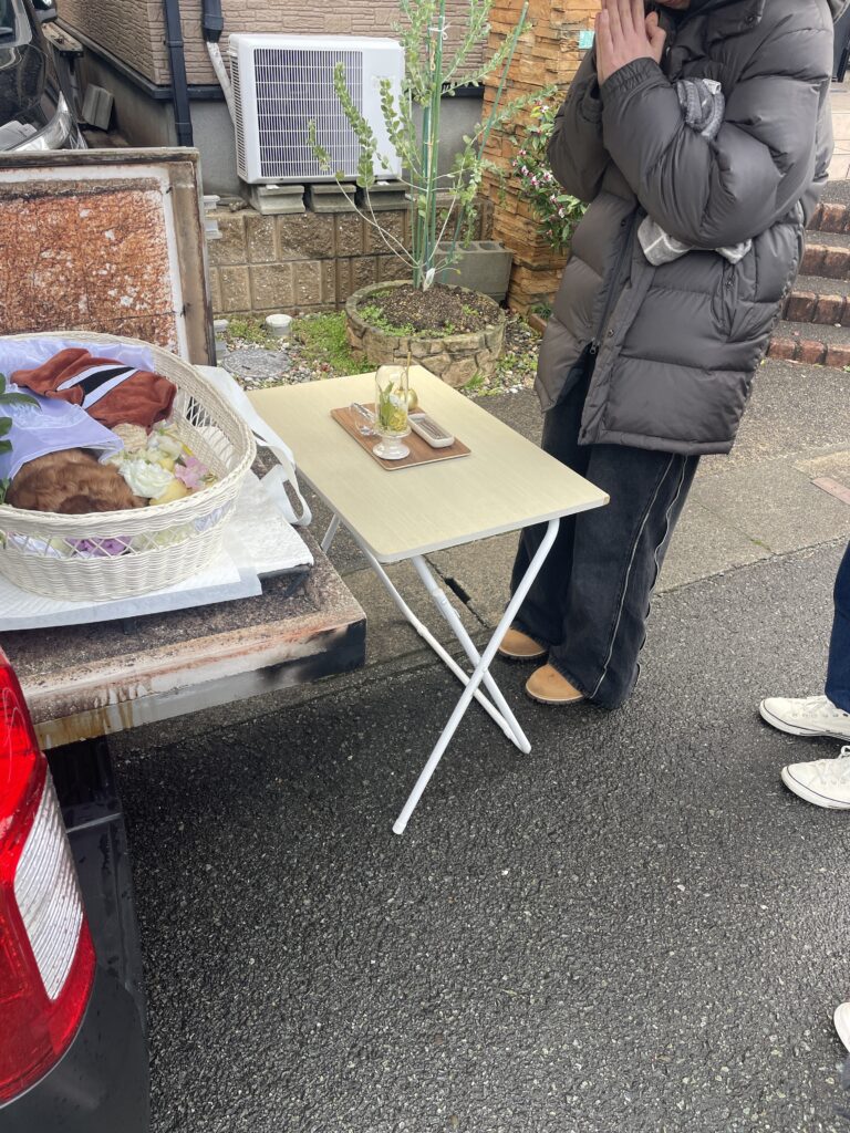 出棺前に合掌するご家族とチコちゃん